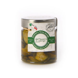 Masseria Calongo Zucchine e Menta in Olio EVO 220g - Le zucchine vengono coltivate in campo aperto nel mese di aprile e raccolte manualmente tra giugno e luglio. Una volta raccolte vengono immediatamente selezionate e lavorate a mano: vengono lavate, affettate e sistemate in apposite vasche per la salatura. Una volta persi i liquidi in eccesso, vengono nuovamente lavate con acqua e aceto e sistemate nei vasetti con olio extravergine di oliva biologico, aglio, peperoncino e menta, che dona un sentore particolarmente fresco.  Le Zucchine e Menta sono una tipica ricetta pugliese, tramandata dalle nonne, un piacevole contorno o antipasto dal gusto rinfrescante. Sono ideali, inoltre, per arricchire panini o sandwich. - Masseria Calongo è una realtà che sorge in Valle d'Itria, una porzione di territorio nella parte centrale della Puglia, a cavallo tra le province di Bari e Brindisi. Tutte le fasi, dalla coltivazione della materia prima, alla lavorazione, fino al confezionamento del prodotto finito, vengono gestite interamente dall'azienda agricola Masseria Calongo. Viene inoltre utilizzato solo olio extravergine di oliva di produzione propria per tutte le conserve di verdura, proponendo quindi sul mercato un prodotto sano, di qualità, a Km Zero e 100% Made in Puglia.