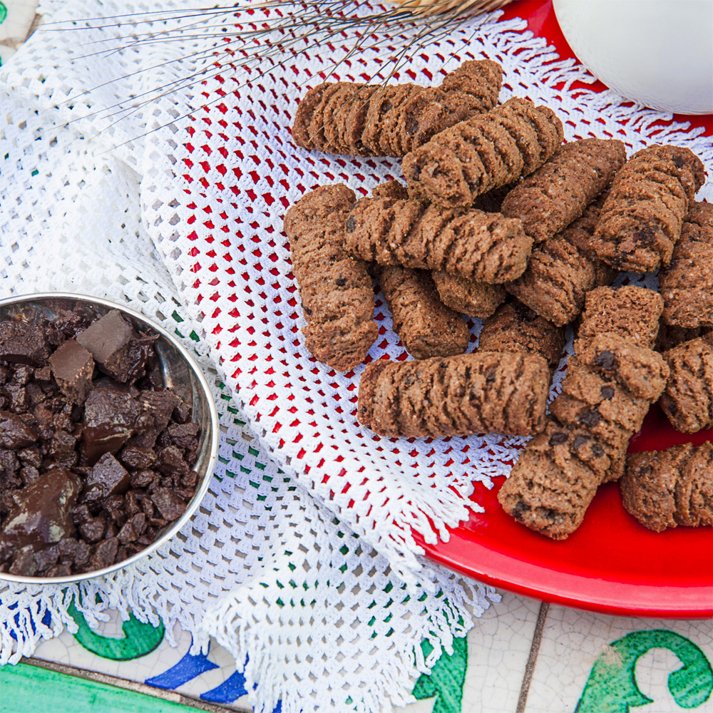 Tumminello Latta GraniSi Biscottini con Cioccolato di Modica IGP 270g – GraniSi è la linea di biscotti ai grani antichi siciliani biologici, senza uso di erbicidi e macinati rigorosamente a pietra.Si contraddistinguono per l’alta digeribilità, grazie ad un legame del glutine debole: sono indicati anche per coloro i quali soffrono di gluten sensitivity (si stima l’8% dei cittadini italiani). TALÌA, TASTALI, ARRICRÌATI (guarda, assaggiali, godine): Solo i più antichi grani siciliani macinati a pietra, il segreto della lavorazione del cioccolato di Modica bassissima temperatura, e il ritorno agli ingredienti di un tempo… la Manna. BISCOTTINI AL CIOCCOLATO DI MODICA IGP: L’originale “Cioccolato di Modica IGP” fondente, mescolato con lo zucchero di canna integrale biologico mascobado, sposa i grani antichi siciliani Tumminia e Maiorca.Nascono così dei deliziosi biscotti realizzati secondo i procedimenti della lavorazione artigianale. Dimensione latta: 16x11x10 cm