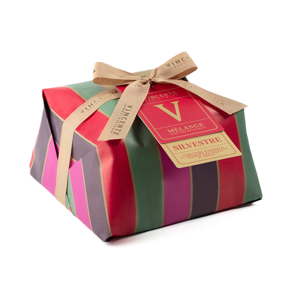 Vincente Delicacies Panettone "Silvestre" con frutti di bosco canditi e ricoperto di cioccolato bianco 750g - Il Panettone artigianale è senza dubbio il simbolo del Natale in tutte le case degli italiani. "Silvestre", prodotto da Vincente Delicacies, si caratterizza per il suo impasto morbidissimo, arricchito dalla copertura di finissimo cioccolato bianco e frutti di bosco canditi. L'elegante incarto avvolge un dolce tenero e profumato: ogni assaggio immerge il palato in un piacere dal gusto intenso e delicato. Questo Panettone incartato a mano fa parte della nuovissima linea "Melange", creata appositamente da Vincente per i palati con gusti raffinati, aperti all'innovazione. Vincente custodisce i metodi di elaborazione e nutrimento della pasta madre, un segreto per ottenere la lievitazione perfetta, fragrante e profumata dalle antiche pratiche di lavorazione, rimaste inalterate nel tempo.