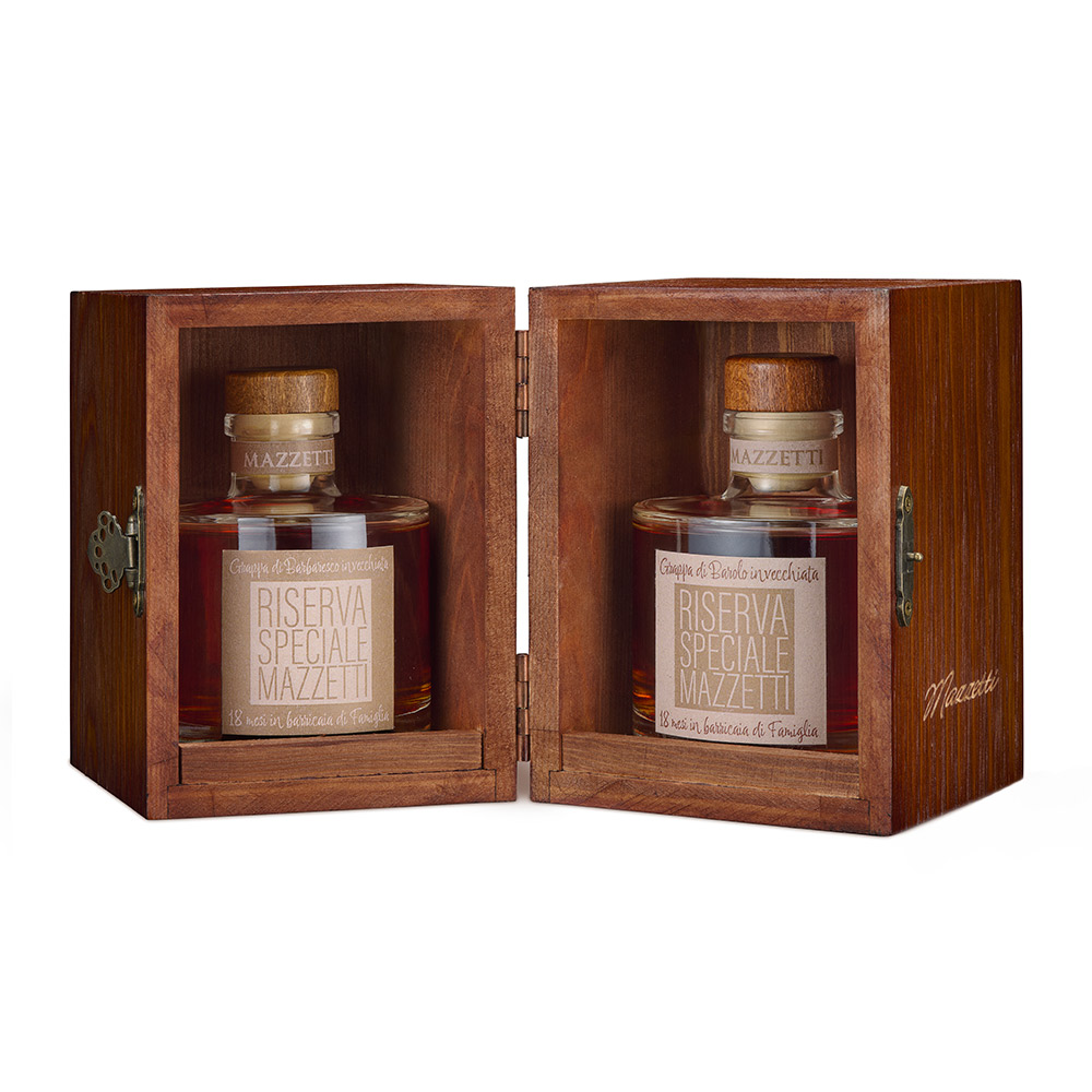 Mazzetti Riserve Speciali Grappa di Barolo e Barbaresco: l’essenza di Langa racchiusa in un unico scrigno.In questa prestigiosa confezione regalo in legno è custodito tutto il tesoro del Nebbiolo, il vitigno che ha fatto la fortuna delle colline langarole e che trova nel Barolo e nel Barbaresco le sue massime espressioni, capaci di affascinare il mondo intero. Dopo paziente riposo in legni pregiati per 18 mesi, nascono distillati di grande complessità come le Riserve di Barolo e Barbaresco pronte per un’attenta degustazione. Pregiato cofanetto in legno contenente: 1 x Grappa Riserva Speciale Barolo 0,20L e 1 x Grappa Riserva Speciale Barbaresco 0,20L