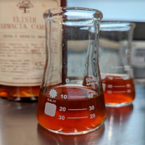 L'Elisir China e Arancio Amaro è realizzato interamente nel laboratorio interno della storica Farmacia Camboa di Uggiano La Chiesa (Lecce). Da generazioni, Vanni, Alessandro e Carola Camboa tramandano con passione la tradizione di famiglia, mantenendo viva l’eredità trasmessa dal Dott. Uccio Camboa nel lontano 1948, per creare un prodotto unico e senza tempo. Le botaniche di questo Elisir digestivo sono China (Cinchona succirubra), Arancio Amaro (Citrus aurantium L. ssp. Amara) e olio essenziale di Arancio Dolce (Citrus sinensis L. var. Dulcis). Si presenta con un colore ambrato scuro, mentre al naso dominano indubbiamente l'arancia amara e le note legnose e amare della china. Al palato è morbido e deciso, con un corredo aromatico ampio e bilanciato tra le note agrumate dell'arancia amara e l'amaro della china. Il finale è lungo e persistente. Per la preparazione viene utilizzato pochissimo zucchero. La ricetta originale è stata ideata dal Dott. Uccio Camboa nel 1948, un vero e proprio alchimista che diede vita a preparazioni e formulazioni con lo scopo di donare beneficio, guarigione e sollievo ai pazienti. Tra la fine del Settecento e l'inizio dell'Ottocento gli Elisir a base di China venivano utilizzati per il trattamento della malaria, grazie alle proprietà febbrifughe e antimalariche della chinina, il principio attivo estratto dalla corteccia dell’albero di China.