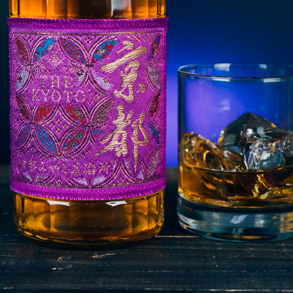 Murasaki-Obi Purple Belt, prodotto dalla Kyoto Miyako Distillery, è un whisky giapponese realizzato esclusivamente con malti di diverso stile, sapientemente miscelati grazie all’uso creativo dei due alambicchi pot still. Alla vista si presenta con un colore ambrato chiaro e luminoso. Al naso offre delicate note salmastre, sentori medicinali e un leggero accenno di fumo. Al palato sorprende per la sua finezza, ottenuta grazie all’impiego dell’alambicco bulge e agli impianti di distillazione, che eliminano impurità e componenti oleose, esaltando invece le sfumature fruttate e floreali. Affinato in botti di Virgin American Oak, questo whisky coniuga raffinatezza ed equilibrio. L’etichetta, realizzata in pregiato tessuto giapponese ricamato, esprime l’eleganza e la tradizione artigianale nipponica.
