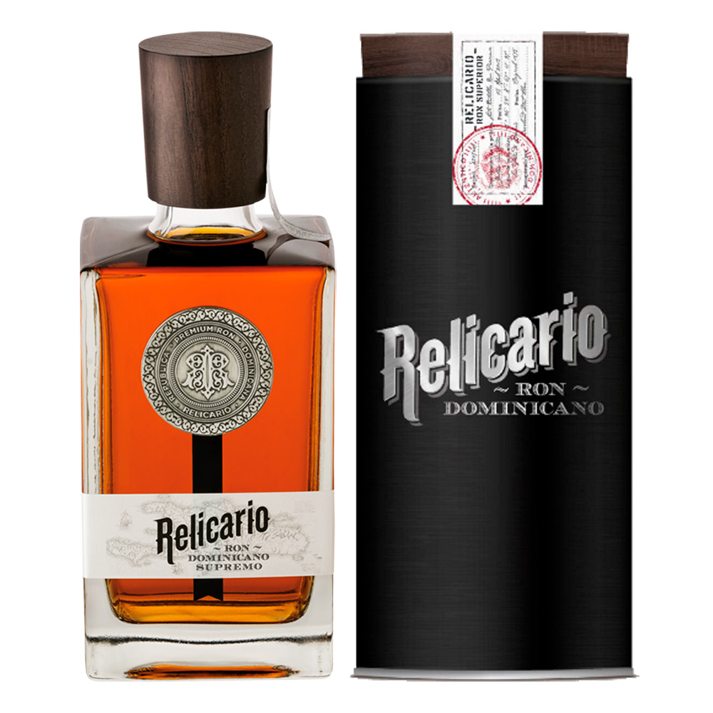 Ron Relicario Supremo nasce da una storia ricca di tradizione, raccontata ancora oggi dagli anziani dell’isola di Hispaniola. La leggenda parla di un mercante spagnolo, conosciuto come il Capitano Bennaser, che nel XIX secolo sbarcò a San Pedro Macorís, un tempo conosciuto come il gioiello dei Caraibi. Il capitano, affascinato dal rum di un esperto distillatore che incontrò durante un incontro conviviale, custodì gelosamente il segreto di questo nettare straordinario in un antico reliquiario. Le due bottiglie che ricevette sono state tramandate nel tempo, fino a che non abbiamo potuto scoprire il mistero di questo distillato prezioso. La produzione del Ron Relicario Supremo inizia con una rigorosa selezione di acque ricche di saccarosio provenienti dagli zuccherifici locali. Dopo una distillazione accurata, il rum matura in botti di quercia bianca americana precedentemente utilizzate per l'invecchiamento di Bourbon Whisky del Kentucky. Questo processo conferisce al rum una complessità aromatica unica. Successivamente, viene creato un blend che integra rum invecchiati per almeno 15 anni, dando vita a un prodotto straordinario e di altissima qualità. Ron Relicario Supremo si presenta con un aspetto ambrato scuro e frizzante, trasparente, con sfumature di mogano che ne evidenziano la densità. Il suo aroma è unico, morbido e ben equilibrato, con un bouquet complesso che mescola note primarie di vaniglia, noce di cocco, uve secche e prugne, accompagnato da sentori secondari di legno di quercia, frutta secca e mandorle.Al palato, il rum è raffinato e elegante, con una dolcezza delicata e un sapore che evoca la frutta secca, l’uva dolce e il legno di quercia, arricchito da sottili note affumicate. La sensazione alla deglutizione è quella di un corpo pieno e morbido, con una leggera dolcezza che non è mai stucchevole e un sapore fruttato delle uve secche che lascia una sensazione densa ma senza astringenza. Ron Relicario Supremo è il risultato di una lavorazione meticolosa e di un invecchiamento che si riflette nella sua ricchezza e complessità, rendendolo un rum da degustazione, perfetto per chi cerca un'esperienza sensoriale unica e raffinata.