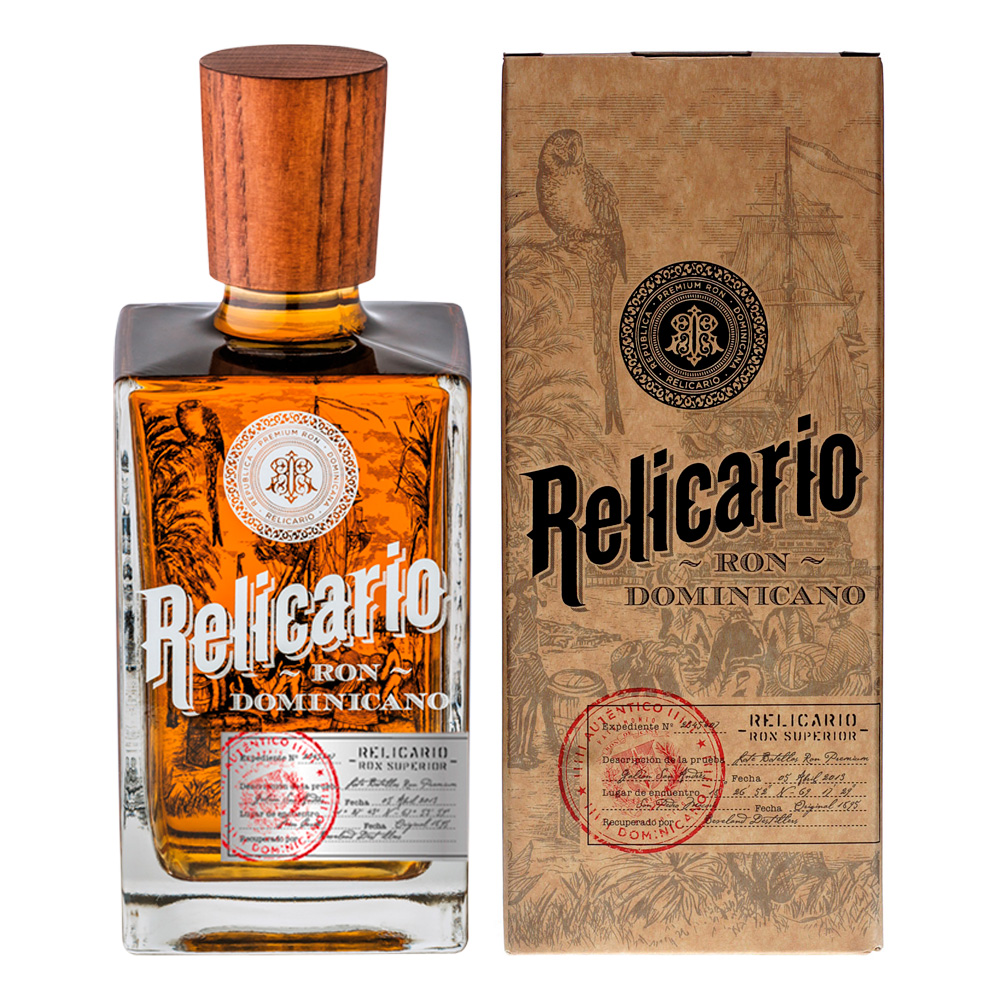 Ron Relicario Superior nasce da una leggenda caraibica, che ancora oggi vive nei racconti degli anziani dell’isola di Hispaniola. La storia narra di un mercante spagnolo, poi conosciuto come il Capitano Bennaser, sbarcato a metà del XIX secolo a San Pedro Macorís, il "gioiello dei Caraibi". In quegli anni difficili, la sua presenza gentile e il suo spirito libero lo resero amato da tutti. Durante una serata conviviale, Bennaser incontrò un anziano distillatore di rum che gli offrì un distillato straordinario. Conquistato da quel nettare raro, il capitano ottenne due bottiglie di questo prezioso liquido, custodendole gelosamente in un antico reliquiario. Tornato in patria, trasmise questo tesoro alla sua famiglia, che per generazioni ne preservò il segreto.-Da questa leggenda nasce Ron Relicario, un rum dominicano che unisce tradizione e autenticità. La produzione parte da una selezione di acque zuccherine provenienti dagli zuccherifici locali, seguita da un'attenta distillazione. Il rum viene poi invecchiato in botti di quercia bianca americana ex-bourbon del Kentucky, che donano complessità, morbidezza e un profilo aromatico unico. Ron Relicario Superior è il risultato dell’unione di rum invecchiati oltre 10 anni con altri rum lavorati diversamente e invecchiati almeno 6 anni. Questo blend crea un distillato raffinato, dal bouquet innovativo e dalla qualità elevata. Alla vista, si presenta limpido, di colore ambrato scuro, con splendidi riflessi quando attraversato dalla luce. Al naso emergono profumi caldi di prugne, uva passa e legno di rovere, con una dolcezza equilibrata. Al palato, il rum rivela il suo lungo invecchiamento: note morbide di vaniglia, mandorla dolce e legno tostato si fondono armoniosamente. La dolcezza è discreta e ben integrata, mentre la consistenza è mediamente viscosa, avvolgendo il palato senza essere aggressiva. La sensazione finale è calda e piacevole, con una leggera nota acidula e una chiusura pulita che riscalda la gola senza irritarla, confermando la finezza dell’alcol e la qualità della lavorazione.