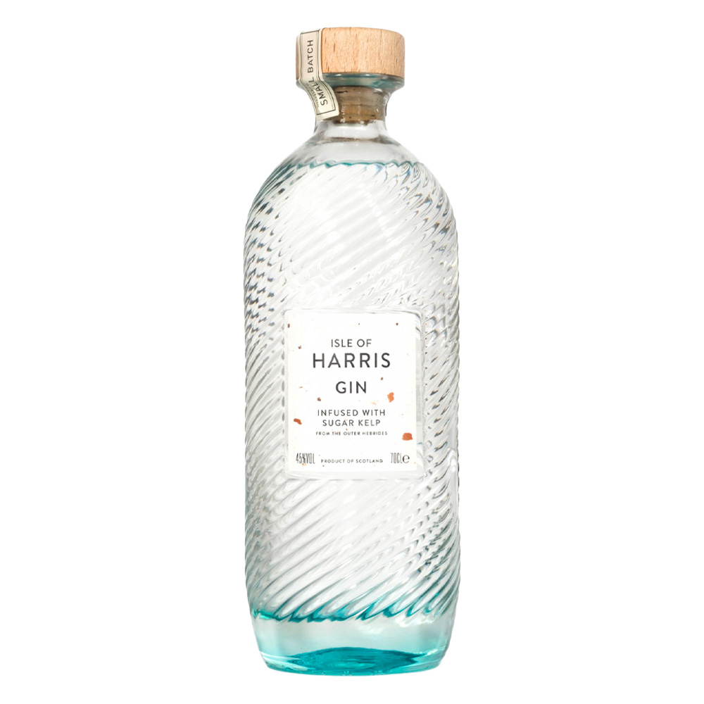 Isle of Harris Gin nasce sull’omonima isola al largo delle coste nord-occidentali della Scozia, nelle selvagge Ebridi Esterne. È un gin artigianale che incarna il carattere marino e autentico del territorio da cui proviene: ventoso, puro, essenziale. Il suo profilo racconta il respiro dell’oceano e i paesaggi incontaminati dell’isola, grazie a una botanica distintiva, l’alga Sugar Kelp, raccolta nei fondali marini locali. Il progetto nasce dal desiderio di Anderson Bakewell di catturare la bellezza e le atmosfere uniche dell’isola in un distillato. La distilleria è stata fondata nel 2015 nel villaggio costiero di Tarbert, e la produzione avviene in piccoli lotti, con un alambicco in rame e acqua purissima proveniente dalla sorgente di Abhainn Cnoc. La ricetta prevede nove botaniche, scelte con cura per esprimere freschezza, eleganza e territorialità: ginepro, scorze di agrumi, erbe, spezie e, soprattutto, Sugar Kelp, che dona al gin una caratteristica nota iodata e salina. Alla vista è cristallino e limpido. Al naso colpisce per la sua eleganza aromatica: note balsamiche di ginepro, aghi di pino, scorza di lime e pompelmo, erbe officinali, pepe bianco e una netta impronta marina. Al palato è armonico e setoso, con una piacevole freschezza salina che accompagna un finale lungo, pulito e balsamico. La bottiglia è un capolavoro di design firmato dallo studio Stranger & Stranger: vetro lavorato con onde in rilievo che evocano il mare, tappo in sughero naturale e un’etichetta minimale, a sottolineare l’eleganza sobria del progetto.