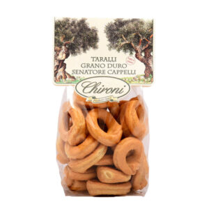 Chironi Taralli al Grano Duro Senatore Cappelli fatti a mano 200g - I Taralli Chironi nascono da un’antica tradizione artigianale: vengono prima bolliti in acqua e poi cotti al forno, per ottenere la giusta croccantezza e un gusto pieno e autentico. Realizzati con grano duro Senatore Cappelli, varietà pregiata e naturale, sono privi di conservanti e additivi, per offrire uno snack sano e digeribile. Perfetti da gustare in ogni momento della giornata, i Taralli Chironi sono ideali come aperitivo o spuntino, da accompagnare con un buon bicchiere di vino o birra e si abbinano alla perfezione con salumi e formaggi. Un prodotto genuino, che porta in tavola la semplicità e la bontà della tradizione pugliese.