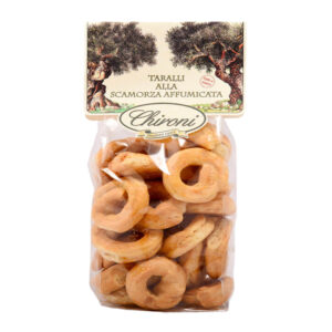 Chironi Taralli alla Scamorza Affumicata fatti a mano 200g - I Taralli Chironi nascono da un’antica tradizione artigianale: vengono prima bolliti in acqua e poi cotti al forno, per ottenere la giusta croccantezza e un gusto pieno e autentico. Realizzati con vino bianco, olio di oliva e scamorza affumicata pugliese. Perfetti da gustare in ogni momento della giornata, i Taralli Chironi sono ideali come aperitivo o spuntino, da accompagnare con un buon bicchiere di vino o birra e si abbinano alla perfezione con salumi e formaggi. Un prodotto genuino, che porta in tavola la semplicità e la bontà della tradizione pugliese.