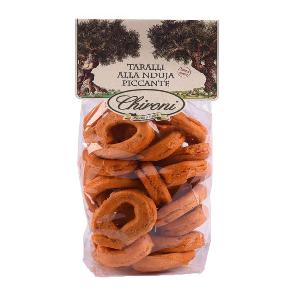 Chironi Taralli alla 'Nduja Piccante fatti a mano 200g - I Taralli Chironi nascono da un’antica tradizione artigianale: vengono prima bolliti in acqua e poi cotti al forno, per ottenere la giusta croccantezza e un gusto pieno e autentico. Realizzati con vino bianco, olio di oliva e 'nduja calabrese piccante. Perfetti da gustare in ogni momento della giornata, i Taralli Chironi sono ideali come aperitivo o spuntino, da accompagnare con un buon bicchiere di vino o birra e si abbinano alla perfezione con salumi e formaggi. Un prodotto genuino, che porta in tavola la semplicità e la bontà della tradizione pugliese.