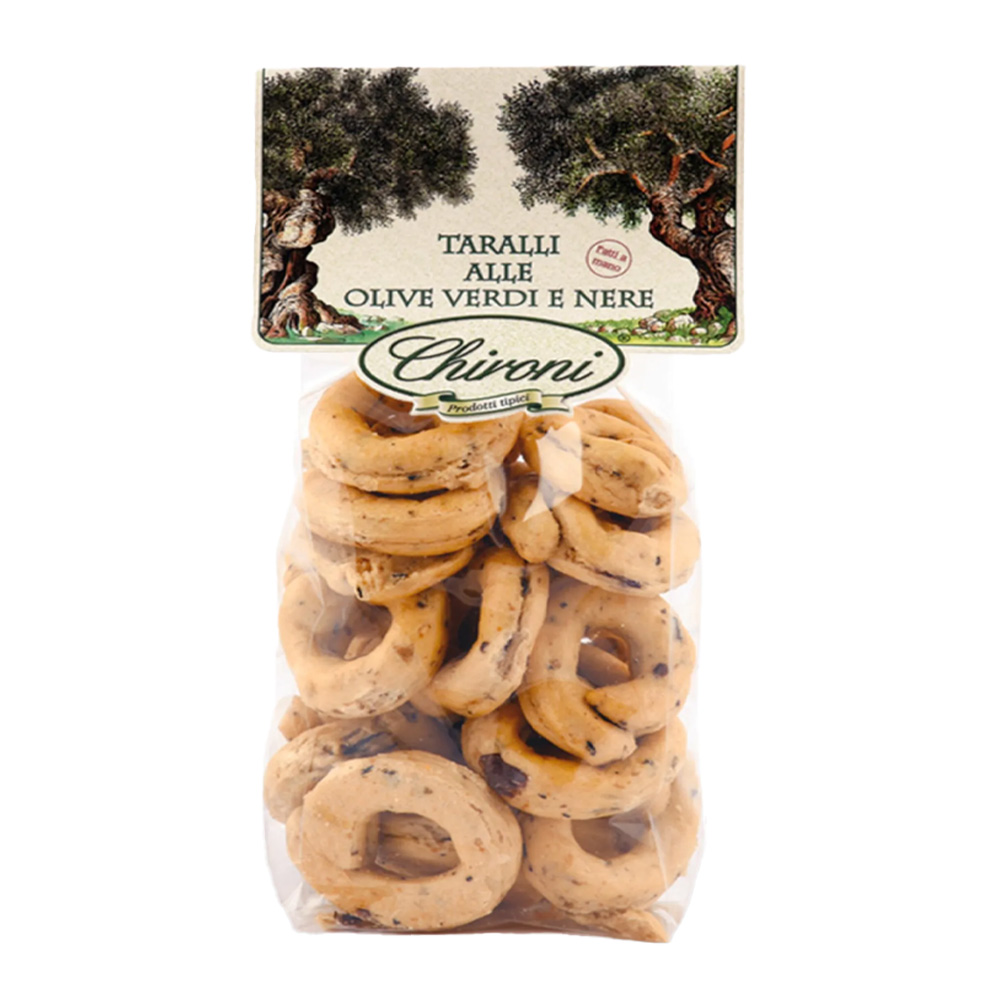 Chironi Taralli alle Olive Verdi e Nere fatti a mano 200g - I Taralli Chironi nascono da un’antica tradizione artigianale: vengono prima bolliti in acqua e poi cotti al forno, per ottenere la giusta croccantezza e un gusto pieno e autentico. Realizzati con vino bianco, olio di oliva e olive verdi e nere. Perfetti da gustare in ogni momento della giornata, i Taralli Chironi sono ideali come aperitivo o spuntino, da accompagnare con un buon bicchiere di vino o birra e si abbinano alla perfezione con salumi e formaggi. Un prodotto genuino, che porta in tavola la semplicità e la bontà della tradizione pugliese.