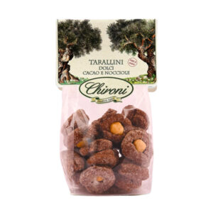 Chironi Tarallini Dolci al Cacao e Nocciole fatti a mano 150g - I tarallini dolci hanno origine nel sud Italia, in particolare in Puglia, dove da secoli accompagnano le celebrazioni familiari e i momenti di festa. Nati dalla semplicità degli ingredienti disponibili nelle case contadine - farina, zucchero, vino bianco, mandorle e olio d’oliva - hanno saputo trasformarsi nel tempo in una delle specialità più amate della tradizione dolciaria regionale. La loro forma ad anello non è casuale: simboleggia l’unità familiare e il ciclo della vita, rendendo ogni morso un piccolo richiamo alle radici e al senso di condivisione. I Taralli dolci Chironi, realizzati a mano con cura artigianale, uniscono alla friabilità della ricetta tradizionale l’intensità del cacao e la croccantezza naturale delle nocciole. Il risultato è un dolce semplice ma raffinato, perfetto da gustare a colazione, come dessert o da accompagnare con un vino da meditazione.