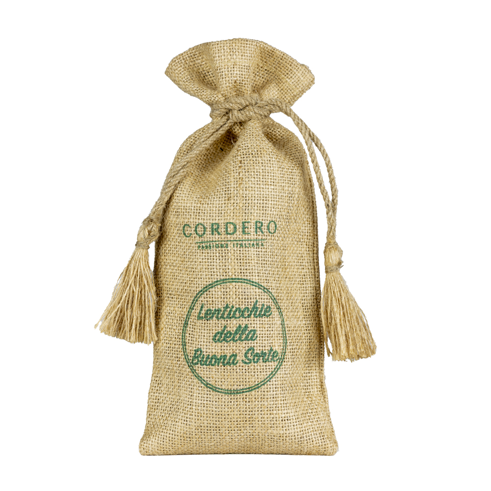 Cordero Lenticchie della Buona Sorte in sacchetto di Juta 300g - Le Lenticchie "della Buona Sorte" Cordero sono di varietà Eston Canada, riconosciute per l’elevata qualità e genuinità dei loro legumi. Piccole e consistenti, sono ricche di proteine, fibre, ferro e vitamine, un alimento naturale e salutare ideale per una dieta equilibrata. Grazie al loro gusto delicato e alla capacità di mantenere la forma dopo la cottura, si prestano a innumerevoli ricette: dalle zuppe cremose alle insalate fresche, fino a piatti unici nutrienti se abbinate ai cereali. Un legume prezioso e versatile, perfetto per chi desidera benessere a tavola senza rinunciare al sapore autentico della tradizione. Preparazione: Mettere in ammollo in acqua tiepida per 12 ore. Scolare e risciaquare il prodotto e cuocere a piacimento in acqua o brodo per circa 20 minuti. In caso di cottura in pentola a pressione, i tempi di cottura si dimezzano.
