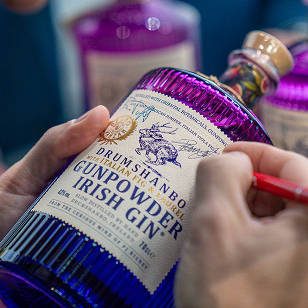 Drumshanbo Gunpowder Irish Gin Italian Fig & Laurel è un gin irlandese artigianale, distillato lentamente in tradizionali alambicchi di rame.Nasce dall’incontro tra la curiosità inesauribile del suo creatore, PJ Rigney, e la maestria artistica del bartender Bruno Vanzan, due esploratori uniti dal desiderio di fondere culture e sapori. Dalla loro collaborazione prende vita una creazione che unisce l’anima selvaggia dell’Irlanda all’eleganza mediterranea dell’Italia, grazie all’aggiunta di fico viola italiano, alloro e ginepro toscano alle botaniche tradizionali del Gunpowder. Rispetto alla versione classica, Italian Fig & Laurel mantiene il perfetto equilibrio tra le note speziate e agrumate tipiche della gamma, ma si distingue per la dolcezza vellutata del fico, la fresca aromaticità dell’alloro e la profondità balsamica del ginepro toscano. Il fico viola, frutto simbolo della tradizione mediterranea, apporta una naturale rotondità e un tocco soave al profilo aromatico, mentre l’alloro dona eleganza e una piacevole nota verde che richiama il profumo delle coste italiane. Alla vista si presenta limpido e cristallino. Al naso emergono sentori vegetali e fruttati, con note di tè, fico maturo e un accenno erbaceo di alloro. Al palato è fresco e rotondo, con un perfetto bilanciamento tra le note balsamiche di ginepro e quelle dolci e persistenti del fico, che accompagnano verso un finale lungo, morbido e raffinato. Il Gin Gunpowder nasce dall’estro di PJ Rigney, fondatore della Shed Distillery. Esploratore curioso e instancabile, PJ ha viaggiato per anni tra Cina, Cambogia, India, Macedonia, Marocco e Germania, fino a stabilirsi nella selvaggia e incontaminata Drumshanbo, nella contea di Leitrim, sulle rive del Lough Allen. È qui che ha dato vita alla sua distilleria, unendo botaniche orientali e irlandesi con metodi di distillazione tradizionali e artigianali.