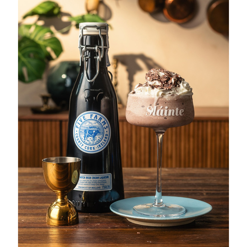 Nato nella Contea di Cork, la più meridionale e rigogliosa d’Irlanda, Five Farms Irish Cream Liqueur rappresenta la vera essenza del concetto “dalla fattoria alla tavola”. Realizzato con panna fresca proveniente da cinque fattorie a conduzione familiare, il suo carattere autentico e genuino nasce da un profondo legame con la terra. La crema, raccolta e combinata con whiskey irlandese premium entro 48 ore, dà vita a un liquore alla crema ricco, vellutato e intensamente aromatico. Premiato come Miglior Irish Cream Liqueur al mondo (Chairman’s Trophy, Ultimate Spirits Challenge 2018), Five Farms si distingue per la quantità superiore di whisky utilizzata rispetto agli altri marchi, che conferisce calore, profondità e un perfetto equilibrio con la dolcezza della crema. Al naso rivela note di caramello, burro e vaniglia, mentre al palato conquista con sfumature di caffè, panna fresca, cocco, acero e waffle belgi. Il risultato è un liquore alla crema irlandese superiore, morbido e avvolgente, ideale da gustare dopo cena al posto del dessert, servito liscio, con ghiaccio o versato sul gelato per un momento di puro piacere. Un’autentica celebrazione della tradizione rurale e distillatoria della Contea di Cork, dove le “mucche felici” pascolano all’aria marina su prati verde smeraldo, donando al latte una qualità senza eguali.