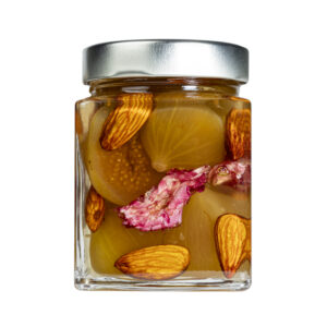 La Mostarda di Fichi, Mandorle e Begonie rappresenta un incontro sorprendente tra eleganza e creatività, una variante innovativa capace di unire la morbida dolcezza dei fichi maturi alla croccante delicatezza delle mandorle, impreziosita dal tocco raffinato e aromatico dei petali di begonia. Le begonie, con il loro profumo leggermente agrumato e la nota acidula naturale, donano alla preparazione una freschezza floreale che bilancia perfettamente la dolcezza del frutto e la rotondità delle mandorle.Il risultato è una mostarda dal profilo complesso e armonioso, elegante sia nel gusto che nell’aspetto: i petali di begonia impreziosiscono la composizione con un tocco estetico di prestigio, rendendola unica e scenografica anche alla vista.-Perfetta in abbinamento con formaggi stagionati, carni bianche delicate o piatti gourmet di ispirazione creativa, questa mostarda diventa un elemento capace di trasformare ogni assaggio in un’esperienza sensoriale completa, dove frutta, fiore e spezia dialogano in modo sorprendente e raffinato. Grado di piccantezza generale: 9. Per le mostarde di frutta di Fredo vengono utilizzate solo le migliori materie prime di origine italiana. Fredo vanta una lunga storia di produzione artigianale di mostarda e frutta candita, iniziata nel lontano 1890 a Brissago (Canton Ticino). Prodotta in esclusiva per EnoArt Enoteca da Fredo SA nel laboratorio di Cadenazzo (Svizzera). Prodotto artigianale, lavorato e confezionato a mano. Formato: Vasetto 400g
