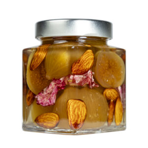 La Mostarda di Fichi, Mandorle e Begonie rappresenta un incontro sorprendente tra eleganza e creatività, una variante innovativa capace di unire la morbida dolcezza dei fichi maturi alla croccante delicatezza delle mandorle, impreziosita dal tocco raffinato e aromatico dei petali di begonia. Le begonie, con il loro profumo leggermente agrumato e la nota acidula naturale, donano alla preparazione una freschezza floreale che bilancia perfettamente la dolcezza del frutto e la rotondità delle mandorle.Il risultato è una mostarda dal profilo complesso e armonioso, elegante sia nel gusto che nell’aspetto: i petali di begonia impreziosiscono la composizione con un tocco estetico di prestigio, rendendola unica e scenografica anche alla vista.-Perfetta in abbinamento con formaggi stagionati, carni bianche delicate o piatti gourmet di ispirazione creativa, questa mostarda diventa un elemento capace di trasformare ogni assaggio in un’esperienza sensoriale completa, dove frutta, fiore e spezia dialogano in modo sorprendente e raffinato. Grado di piccantezza generale: 9. Per le mostarde di frutta di Fredo vengono utilizzate solo le migliori materie prime di origine italiana. Fredo vanta una lunga storia di produzione artigianale di mostarda e frutta candita, iniziata nel lontano 1890 a Brissago (Canton Ticino). Prodotta in esclusiva per EnoArt Enoteca da Fredo SA nel laboratorio di Cadenazzo (Svizzera). Prodotto artigianale, lavorato e confezionato a mano. Formato: Vasetto 400g
