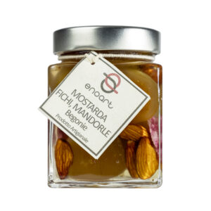 La Mostarda di Fichi, Mandorle e Begonie rappresenta un incontro sorprendente tra eleganza e creatività, una variante innovativa capace di unire la morbida dolcezza dei fichi maturi alla croccante delicatezza delle mandorle, impreziosita dal tocco raffinato e aromatico dei petali di begonia. Le begonie, con il loro profumo leggermente agrumato e la nota acidula naturale, donano alla preparazione una freschezza floreale che bilancia perfettamente la dolcezza del frutto e la rotondità delle mandorle.Il risultato è una mostarda dal profilo complesso e armonioso, elegante sia nel gusto che nell’aspetto: i petali di begonia impreziosiscono la composizione con un tocco estetico di prestigio, rendendola unica e scenografica anche alla vista.-Perfetta in abbinamento con formaggi stagionati, carni bianche delicate o piatti gourmet di ispirazione creativa, questa mostarda diventa un elemento capace di trasformare ogni assaggio in un’esperienza sensoriale completa, dove frutta, fiore e spezia dialogano in modo sorprendente e raffinato. Grado di piccantezza generale: 9. Per le mostarde di frutta di Fredo vengono utilizzate solo le migliori materie prime di origine italiana. Fredo vanta una lunga storia di produzione artigianale di mostarda e frutta candita, iniziata nel lontano 1890 a Brissago (Canton Ticino). Prodotta in esclusiva per EnoArt Enoteca da Fredo SA nel laboratorio di Cadenazzo (Svizzera). Prodotto artigianale, lavorato e confezionato a mano. Formato: Vasetto 400g