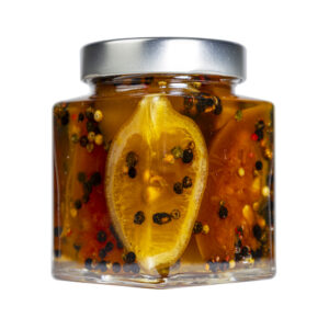 La Mostarda di Pompelmo, Limone e Pepe Rosa rappresenta un connubio elegante tra vivacità agrumata e raffinatezza speziataNasce dall’incontro tra la freschezza del limone, l’amaro gentile del pompelmo e la leggera piccantezza del pepe rosa, che regala equilibrio e complessità al palato. La componente agrumata offre note intense, profumate e luminose, mentre il pepe rosa, con il suo aroma morbido e floreale, aggiunge una sfumatura aromatica sorprendente che esalta e armonizza tutti gli ingredienti. Dal gusto vivace e raffinato, questa mostarda è perfetta in abbinamento a formaggi stagionati, arrosti di maiale o pollo, bolliti e salumi saporiti.Ideale anche per dare un tocco gourmet a piatti estivi, antipasti raffinati e ricette creative, esprime una personalità moderna e brillante, capace di conquistare con la sua eleganza e freschezza persistente. Grado di piccantezza generale: 9. Per le mostarde di frutta di Fredo vengono utilizzate solo le migliori materie prime di origine italiana. Fredo vanta una lunga storia di produzione artigianale di mostarda e frutta candita, iniziata nel lontano 1890 a Brissago (Canton Ticino). Prodotta in esclusiva per EnoArt Enoteca da Fredo SA nel laboratorio di Cadenazzo (Svizzera). Prodotto artigianale, lavorato e confezionato a mano. Formato: Vasetto 400g