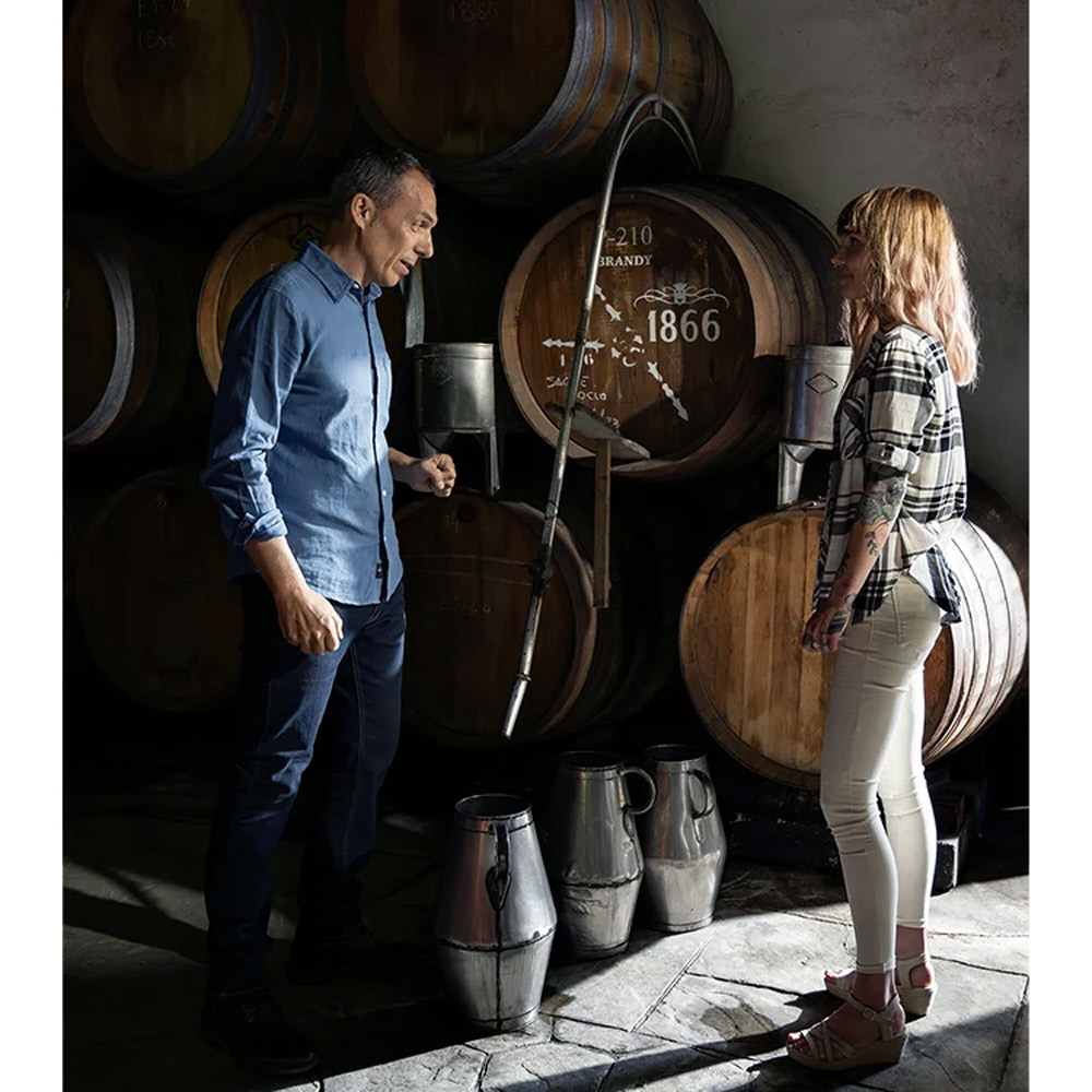 Osborne 1866 Brandy Solera Gran Reserva rappresenta l’eccellenza dell’arte distillatoria spagnola, un capolavoro nato da oltre 150 anni di tradizione e dal leggendario sistema “criaderas y solera” composto da 16 livelli di botti di rovere. Questa edizione limitata, creata in collaborazione con l’artista svedese Emma Lindström, unisce la maestria del blending di brandy e l’energia del colore fluido, celebrando l’armonia tra arte e tempo. Distillato da vini Airén della Mancia nelle tradizionali alquitaras di rame, il Brandy 1866 matura per una media di dodici anni in botti che hanno precedentemente contenuto i migliori sherry di Osborne. Il risultato è un brandy ricco, profondo e vellutato, dal colore mogano intenso con riflessi dorati, capace di conquistare gli appassionati più esigenti. Al naso rivela note di uvetta, vaniglia e caramello, mentre al palato esprime frutta secca, legni nobili e accenti salmastri che ne definiscono la morbidezza e la finezza. Il finale è lungo, caldo e rotondo, con una piacevole dolcezza bilanciata da tocchi secchi e speziati. Ogni bottiglia della Limited Edition 1866 x Emma Lindström è un’opera d’arte: i toni ambra, oro e terra evocano i colori del brandy e del paesaggio andaluso di El Puerto de Santa María, dove nasce e invecchia.Un brandy leggendario, simbolo di passione, equilibrio e tradizione, che racchiude nel suo profumo tutta la storia e l’anima dell’Andalusia.