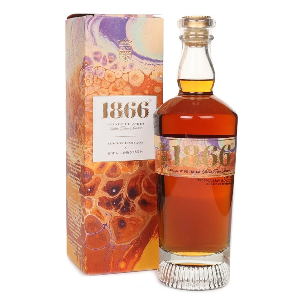 Osborne 1866 Brandy Solera Gran Reserva rappresenta l’eccellenza dell’arte distillatoria spagnola, un capolavoro nato da oltre 150 anni di tradizione e dal leggendario sistema “criaderas y solera” composto da 16 livelli di botti di rovere. Questa edizione limitata, creata in collaborazione con l’artista svedese Emma Lindström, unisce la maestria del blending di brandy e l’energia del colore fluido, celebrando l’armonia tra arte e tempo. Distillato da vini Airén della Mancia nelle tradizionali alquitaras di rame, il Brandy 1866 matura per una media di dodici anni in botti che hanno precedentemente contenuto i migliori sherry di Osborne. Il risultato è un brandy ricco, profondo e vellutato, dal colore mogano intenso con riflessi dorati, capace di conquistare gli appassionati più esigenti. Al naso rivela note di uvetta, vaniglia e caramello, mentre al palato esprime frutta secca, legni nobili e accenti salmastri che ne definiscono la morbidezza e la finezza. Il finale è lungo, caldo e rotondo, con una piacevole dolcezza bilanciata da tocchi secchi e speziati. Ogni bottiglia della Limited Edition 1866 x Emma Lindström è un’opera d’arte: i toni ambra, oro e terra evocano i colori del brandy e del paesaggio andaluso di El Puerto de Santa María, dove nasce e invecchia.Un brandy leggendario, simbolo di passione, equilibrio e tradizione, che racchiude nel suo profumo tutta la storia e l’anima dell’Andalusia.