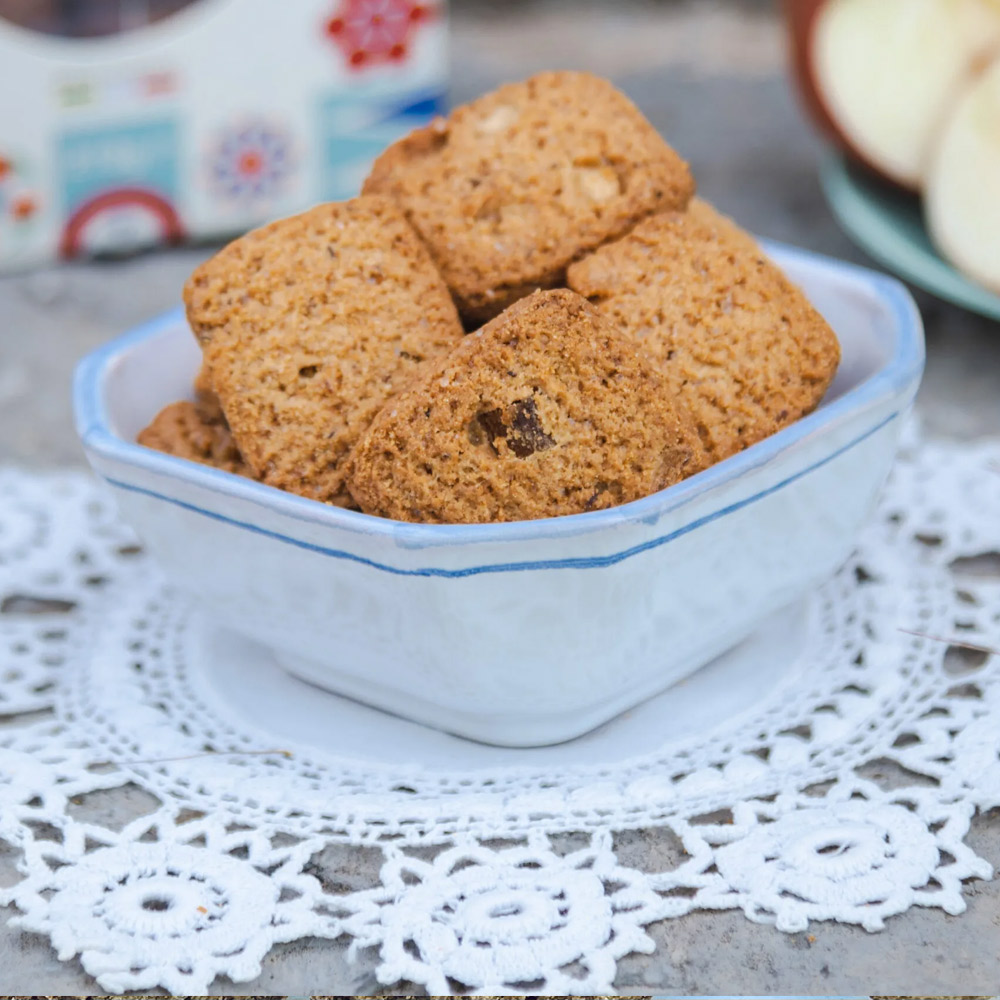 Tumminello Latta GraniSi Biscottini Mela e Cannella 270g - I Biscottini con Mela Candita e Cannella del Biscottificio Tumminello uniscono semplicità e genuinità. La mela candita e la cannella richiamano il profumo avvolgente di una torta di mele, mentre le farine di grani antichi siciliani Timilia e Maiorca, macinate a pietra, regalano una consistenza rustica e un gusto autentico. Naturali e fragranti, sono perfetti a colazione da inzuppare nel latte, sbriciolati nello yogurt come granola, oppure con una tazza di tè. Una pausa dolce e salutare, che profuma di casa. GraniSi è la linea di biscotti ai grani antichi siciliani biologici, senza uso di erbicidi e macinati rigorosamente a pietra.Si contraddistinguono per l'alta digeribilità, grazie ad un legame del glutine debole: sono indicati anche per coloro i quali soffrono di gluten sensitivity (si stima l'8% dei cittadini italiani). TALÌA, TASTALI, ARRICRÌATI. (guarda, assaggiali, godine). Dimensione latta: 16x11x10 cm