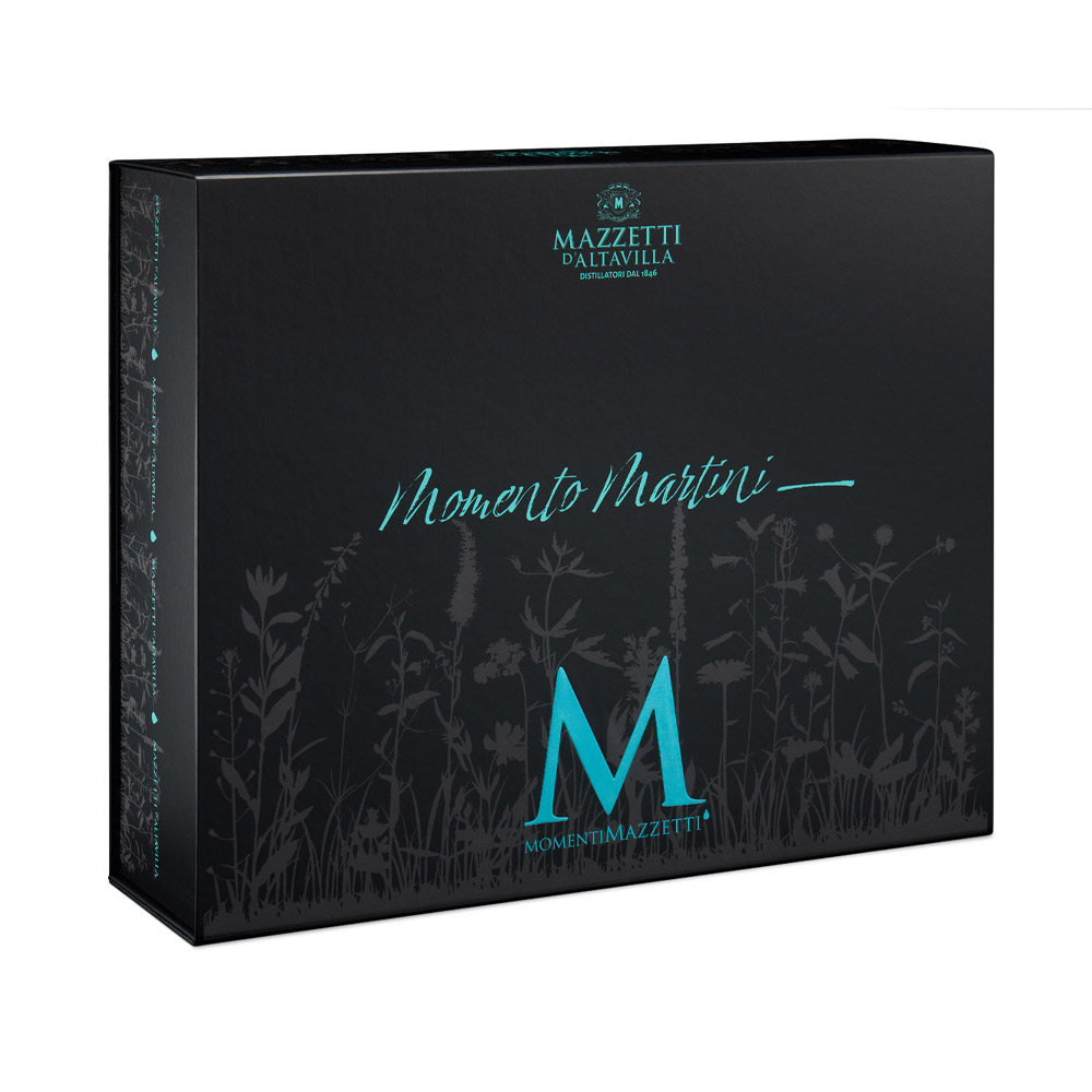 Mazzetti Momento Martini con Gin Black Edition e Accessori - Non è un semplice cocktail: il Martini è un rito. Con Momento Martini, Mazzetti d’Altavilla celebra l’icona della miscelazione internazionale racchiudendo in un’unica confezione tutto il necessario per prepararlo alla perfezione. Protagonista del cofanetto è il Gin Black Edition, elegante e deciso, con note botaniche fini e pulite che si sposano idealmente con il Martini dry. Insieme al gin, la confezione include calici dedicati RCR, shaker e accessori dorati, per trasformare ogni preparazione in un gesto consapevole e raffinato. Un kit completo pensato per chi vuole vivere l’esperienza del Martini nel suo stile originale: dal movimento dello shaker al suo tipico profumo aromatico, fino al primo sorso. Non è solo un cocktail.È un momento da celebrare.