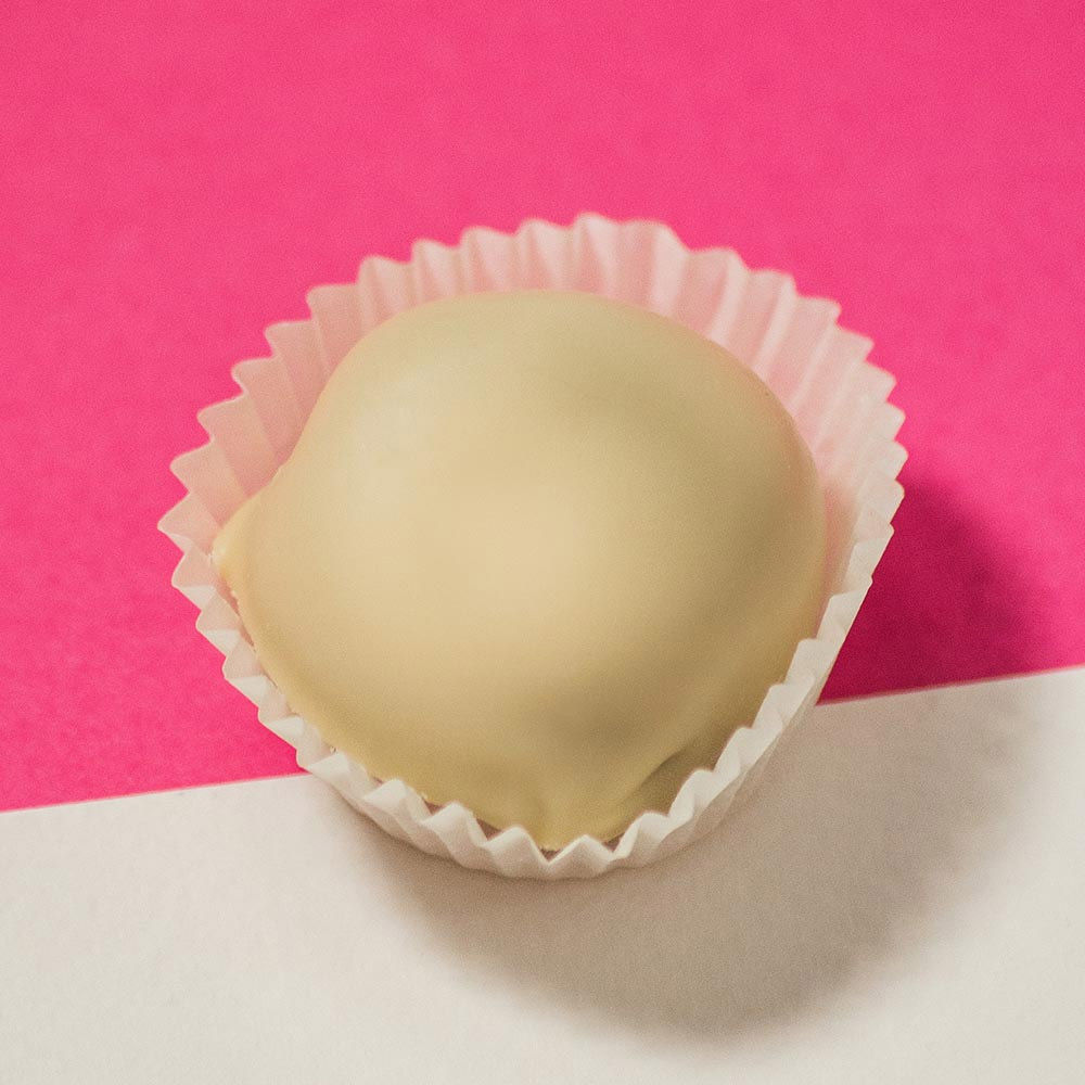Rango Bocconcini di Fichi ricoperti di Cioccolato Bianco 250g - Piccoli tesori di dolcezza dal cuore calabrese.Realizzati con pregiati fichi “Dottati di Calabria”, selezionati manualmente e lasciati essiccare naturalmente al sole, questi bocconcini vengono poi cotti lentamente al forno per esaltarne la morbidezza e la concentrazione aromatica. Successivamente, ogni fico viene ricoperto da un fine strato di cioccolato bianco, creando un equilibrio perfetto tra la dolcezza cremosa della copertura e la ricchezza del frutto. La lavorazione è rigorosamente artigianale: nulla è lasciato al caso. Il risultato è un cioccolatino dalla consistenza morbida e avvolgente, con un gusto che conquista per semplicità e intensità. Un contrasto irresistibile tra frutta e cioccolato, in una confezione elegante che valorizza al massimo il prodotto.