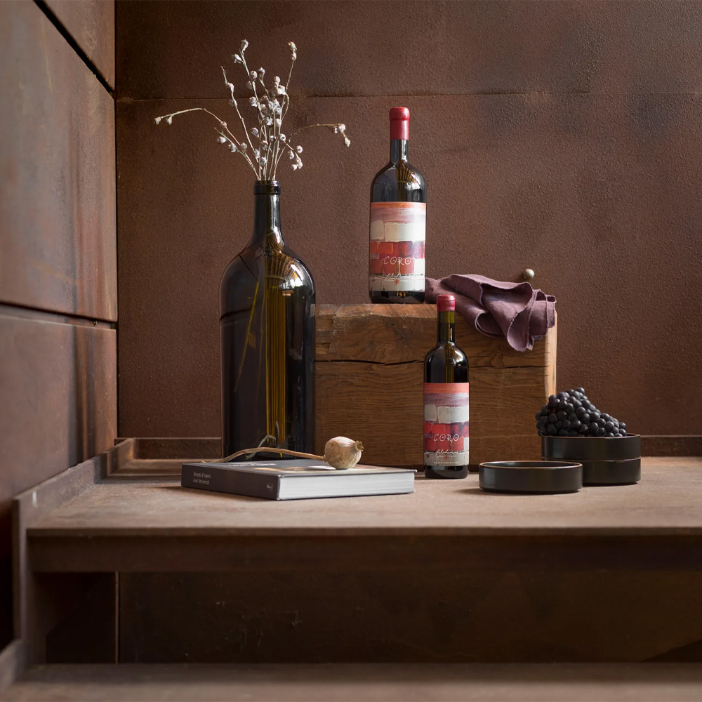 Coro di Filodivino si presenta di colore rosso rubino. Al naso è intenso e molto complesso: profumi floreali si intrecciano a note di erbe aromatiche, frutti di bosco e ciliegia, con tocchi di humus e sentori balsamici. In bocca è deciso e strutturato, con tannini ben integrati e ben educati, e una sorprendente freschezza che bilancia la struttura importante. Il finale è armonioso e persistente. Coro nasce dall'incontro fra il territorio marchigiano di San Marcello e tre vitigni internazionali: Syrah, Cabernet Franc e Merlot. Un'interpretazione originale che fonde l'anima delle Marche con il carattere bordolese, creando un rosso stimolante dove l'armonia è il frutto di inedite relazioni. Le vigne, di 8 anni, sono coltivate a 220-240 metri di altitudine su suoli di argille calcaree e sabbia, in regime biologico certificato. L'affinamento di 18 mesi avviene in tonneaux di rovere francese con diverse tostature.