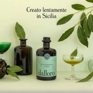 Il Liquore all'Alloro "Dalloro" è un inno alla tradizione liquoristica artigianale siciliana. Realizzato a Palermo dalla giovane realtà Casa Allora, questo digestivo d'eccellenza nasce esclusivamente da botaniche coltivate "ad acqua e sole" nella tenuta di famiglia. Lontano dalle logiche e dalle standardizzazioni industriali, "dalloro" è definito dai suoi creatori un vero e proprio "miracolo di lentezza": i tempi di raccolta, essiccazione e infusione seguono rigorosamente i ritmi naturali, senza l'uso di macchinari, additivi chimici o coloranti. Una filosofia etica che abbraccia anche la sostenibilità ambientale, con un processo produttivo a zero sprechi e un packaging completamente riciclabile, per un liquore che esalta il saper fare artigiano e l'amore puro per la terra madre. - Al naso sprigiona i profumi inconfondibili della macchia mediterranea, con intense e avvolgenti note balsamiche tipiche dell'alloro siciliano. In bocca il sorso è fresco, aromatico e ben equilibrato, capace di restituire intatte le rinomate proprietà benefiche e naturali della pianta. Per apprezzarne al meglio la purezza e l'efficacia digestiva, si consiglia di servirlo rigorosamente freddo o con ghiaccio a fine pasto. La sua spiccata versatilità aromatica lo rende inoltre un ingrediente sorprendente nell'arte della mixology, perfetto per dare un twist mediterraneo ai drink classici o come base per cocktail innovativi.