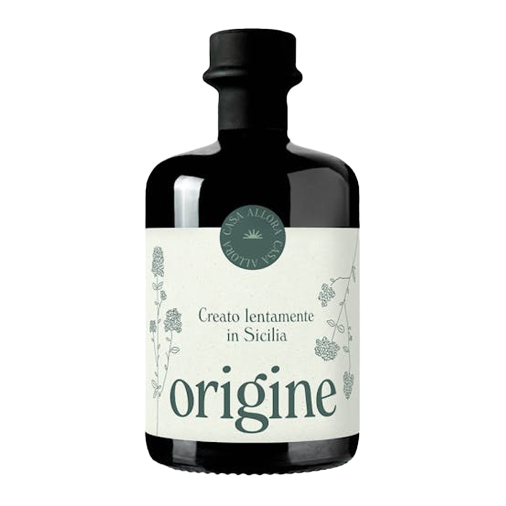 "Origine" di Casa Allora è un liquore dal carattere spiccatamente moderno che celebra in modo inedito un'erba aromatica simbolo del Mediterraneo. Fedele alla filosofia produttiva della giovane realtà palermitana — votata all'elogio della lentezza e al netto rifiuto delle logiche industriali — questo liquore nasce dall'attenta estrazione a freddo degli oli essenziali di puro origano siciliano in infusione alcolica, con la sola aggiunta di acqua e zucchero. Un processo di lavorazione rigorosamente artigianale e manuale, eseguito senza l'uso di additivi chimici o coloranti, che permette di catturare l'anima più autentica della Sicilia in un prodotto genuino, sostenibile e rispettoso dei tempi imposti dalla natura. - Al naso si annuncia con una componente aromatica forte e distintiva, in cui il profumo inconfondibile dell'origano risulta immediatamente riconoscibile e avvolgente. In bocca il sorso offre un'esperienza intensa ma al contempo delicata: l'attacco è nettamente erbaceo, arricchito da leggere ed intriganti note di pepe, per poi distendersi in un finale lungo dalla spiccata balsamicità. Facile e piacevole da bere, "Origine" è eccellente da servire freddo sia come originale aperitivo che come digestivo a fine pasto. La sua incredibile versatilità aromatica lo rende inoltre un ingrediente prezioso nell'arte della mixology, perfetto per dare un twist erbaceo ai grandi classici o come base per cocktail innovativi.