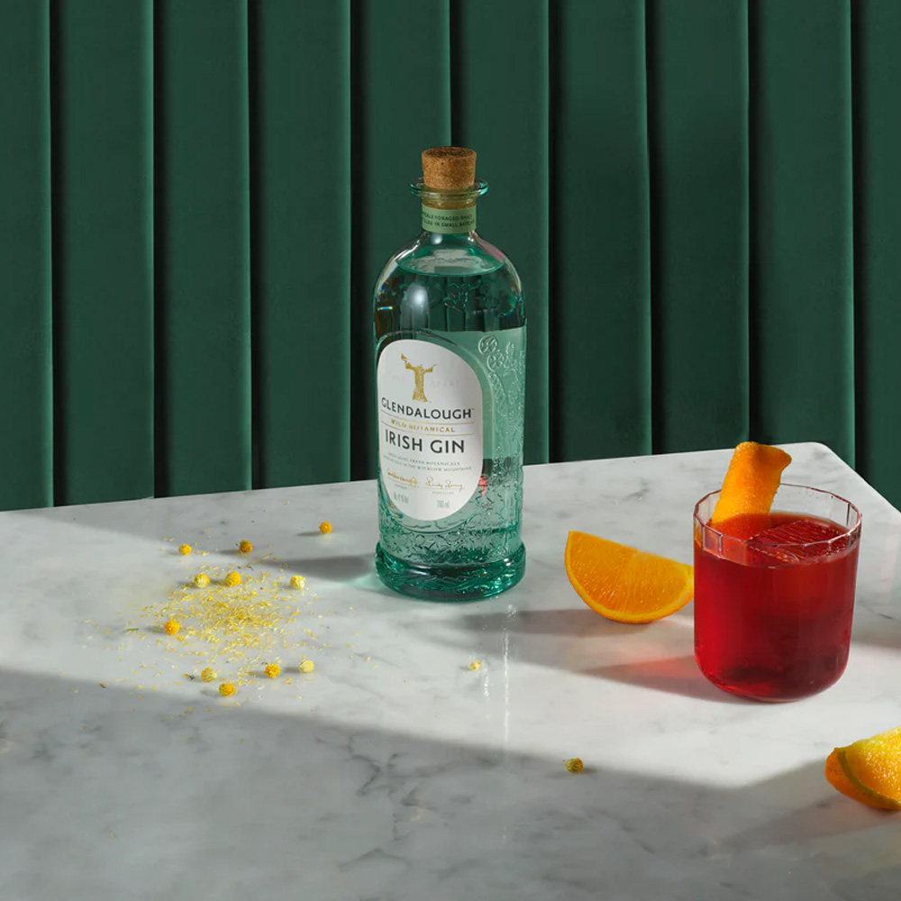 Glendalough Wild Botanical Gin è un gin premium irlandese che celebra la natura incontaminata della contea di Wicklow attraverso botaniche selvatiche raccolte a mano: non essendo coltivate, ogni lotto cambia leggermente e diventa un’esperienza sensoriale unica, legata alla stagione e al clima della raccolta. Viene prodotto in piccoli lotti (circa 2/3 mila bottiglie) e le botaniche vengono lavorate freschissime: alcune vengono lasciate in infusione nello spirito neutro per una notte, altre vengono distillate “in corrente di vapore” per preservare le note più delicate. Il distillato viene poi portato a 41% vol. con acqua delle Wicklow Mountains. Al naso è immediato e riconoscibile, con ginepro e agrumi in primo piano e un ventaglio floreale che richiama prati in fiore; in bocca è fresco e complesso, con un’evoluzione che ricorda le “quattro stagioni”, passando da sensazioni verdi e primaverili a toni più estivi e floreali, toccando frutti più maturi e chiudendo su spezie e accenti balsamici. La distilleria cura attentamente la tracciabilità e l’artigianalità della presentazione: poche bottiglie, etichettate con numero di lotto e bottiglia, data di imbottigliamento e data di raccolta delle botaniche. Dà il meglio di sé in un Gin & Tonic con una tonica neutra, per non coprire il profilo botanico, ma è ottimo anche liscio, proprio per cogliere la sua “firma” vegetale e floreale.