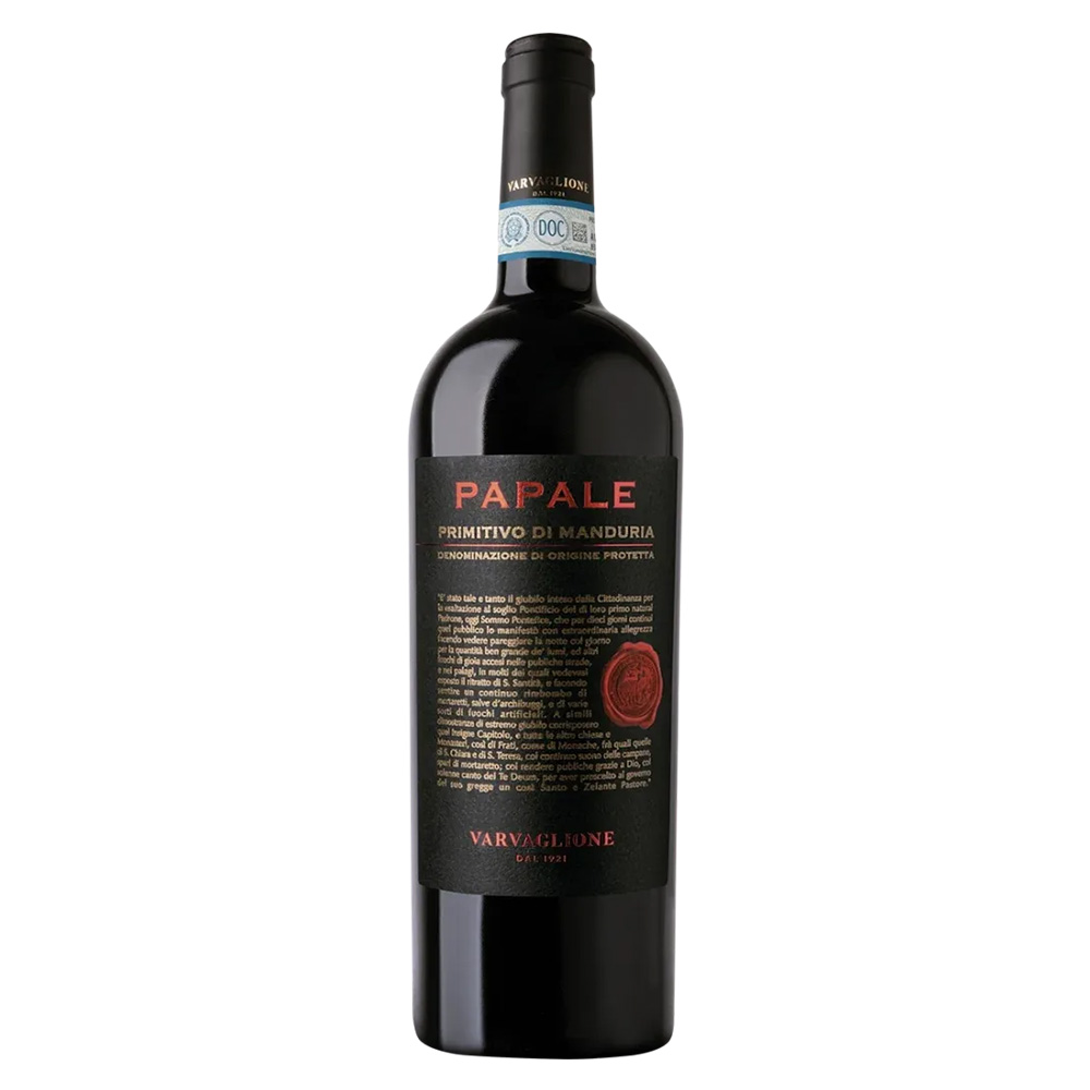 Il Papale Primitivo di Manduria DOP di Varvaglione è un rosso dal fascino mediterraneo, capace di esprimere nel calice tutta l'intensità e il calore del sole pugliese. Si presenta alla vista con un colore rosso carico, profondo, acceso da luminosi e intensi riflessi violacei. Al naso sprigiona un bouquet ricco e avvolgente: decisi sentori di frutti di bosco in confettura — mora, ciliegia, ribes nero e lampone — si intrecciano a morbide ed eleganti note di vaniglia, cioccolato e liquirizia sul finale. Al palato l'impatto è energico ma setoso: un sorso caratterizzato da grande morbidezza, rotondità e calore, ben supportato da un tannino maturo che guida verso una chiusura straordinariamente persistente. ​- Il Primitivo è il vitigno simbolo della zona tarantina, e in particolare a Manduria trova da oltre un secolo il suo habitat d'elezione, grazie a un clima caldo e asciutto che ne favorisce la perfetta maturazione. La storica cantina Varvaglione seleziona le uve in purezza per dare vita a questo rosso identitario. Dopo la vendemmia, la vinificazione avviene in serbatoi di acciaio a temperatura controllata con macerazione sulle bucce. Conclusa la fermentazione malolattica, che ne ingentilisce il profilo, il vino riposa in tonneau di rovere francese per almeno 8 mesi, un affinamento studiato per donargli quella struttura e quella complessità aromatica che lo rendono inconfondibile.