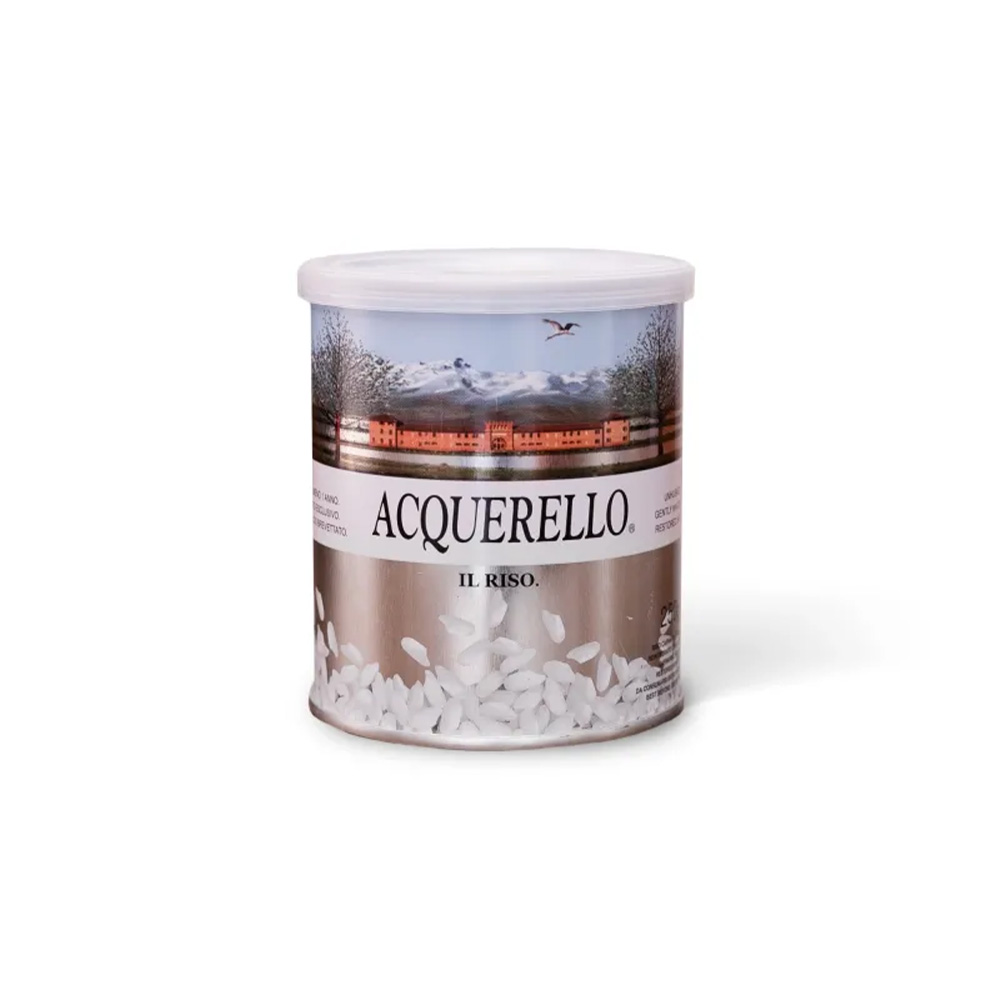 Considerato il "re dei risi" e scelto dai più grandi chef stellati internazionali, il Riso Carnaroli Acquerello è l'ingrediente perfetto per preparare risotti impeccabili. L'intera filiera è curata nei minimi dettagli all'interno della storica Tenuta Colombara, dalla coltivazione fino al confezionamento, garantendo un'eccellenza assoluta per la tua cucina. Questo prodotto rappresenta la vera tradizione gastronomica italiana, portando sulla tua tavola una qualità senza compromessi. - La straordinaria tenuta in cottura di questo riso nasce da un processo rigoroso composto da venti delicati passaggi. Il riso grezzo riposa per almeno un anno all'interno di silos a temperatura controllata inferiore a 15°C, permettendo all'amido di stabilizzarsi in modo naturale. Grazie a questo invecchiamento e a una dolce sbiancatura dei chicchi tramite sfregamento ad elica, il riso disperde meno amido in pentola e aumenta notevolmente la sua capacità di assorbire i condimenti. - Un'altra caratteristica che rende unico l'Acquerello è la capacità di unire il sapore raffinato del riso bianco alle proprietà nutrizionali del riso integrale. Durante la lavorazione, la gemma vitale del chicco viene inizialmente separata per poi essere reintegrata attraverso un esclusivo procedimento brevettato. Questo attento passaggio restituisce al prodotto il suo prezioso patrimonio naturale di vitamine e microelementi. - Il riso è infine custodito in un'iconica lattina pressurizzata con azoto, un sistema all'avanguardia che ne garantisce la massima freschezza e integrità nel tempo. Il formato da 250g è molto pratico da conservare in dispensa e rappresenta anche un'eccellente idea regalo per tutti gli appassionati di cucina. Si presta magnificamente per essere inserito all'interno delle prestigiose confezioni Food & Wine, ideale da abbinare a una grande bottiglia della tua selezione per un cesto natalizio indimenticabile.